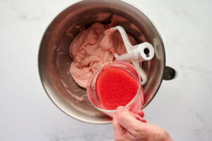 Adding liquid to the vintage cherry cake recipe.