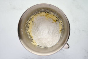 Adding powdered sugar to creamed butter.