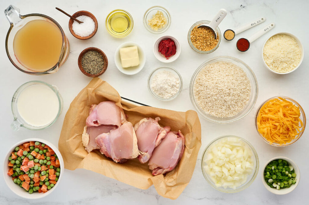 Ingredients used to make chicken and rice from scratch with peas and carrots.