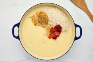 Adding seasoning and rice to the chicken mixture.