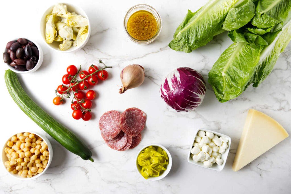 Salad ingredients laying out on a white counter.