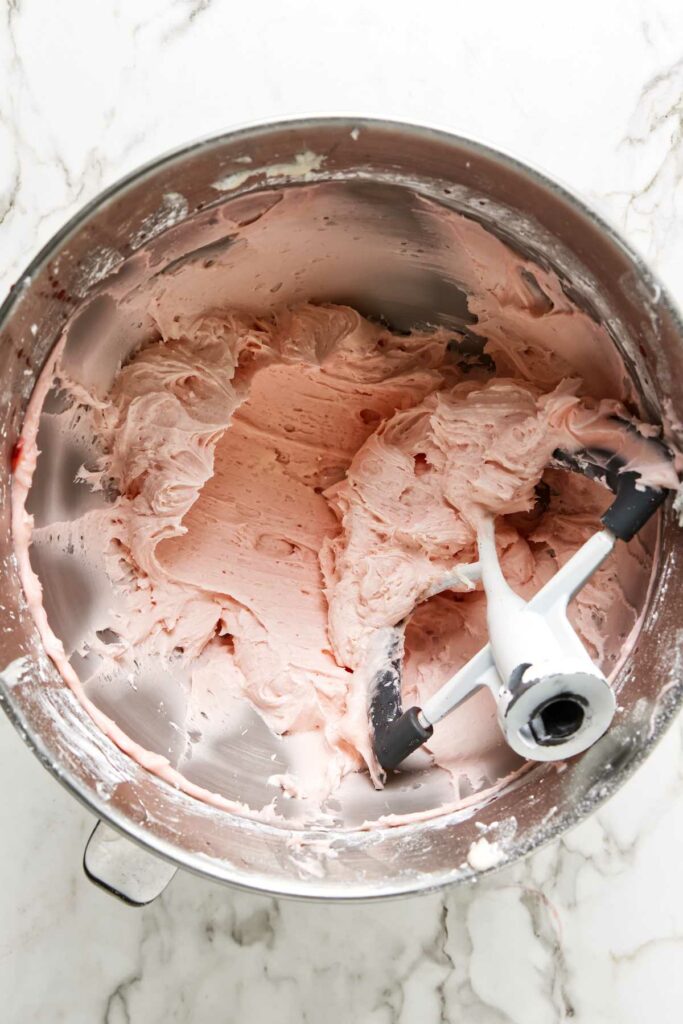 Maraschino cherry buttercream frosting in a mixing bowl.