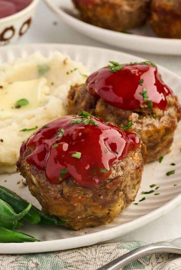 Two muffin pan meatloaf servings on a dinner plate.