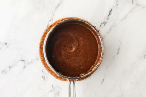 Heating the butter and oil and cocoa powder in a sauce pan.