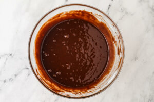 Whisking the chocolate cake batter in a bowl.