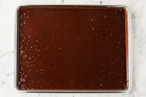 Spreading the cake batter into a half sheet pan to bake the cake.