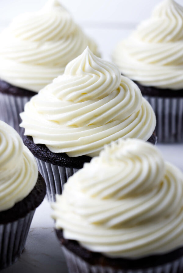 Cupcakes topped with a swirl of sour cream frosting.