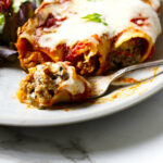 Cannelloni pasta filled with beef and cheese on a plate.