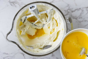 Adding eggs to the cheesecake batter.