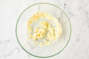 Beating the butter in a mixing bowl.