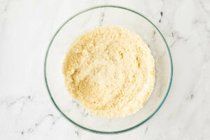 Mixing the flour with the butter to make a shortbread crust.