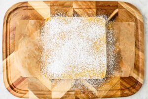 Dusting powdered sugar over homemade lemon bars.