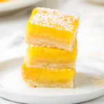 Three creamy lemon bars stacked on top of each other.