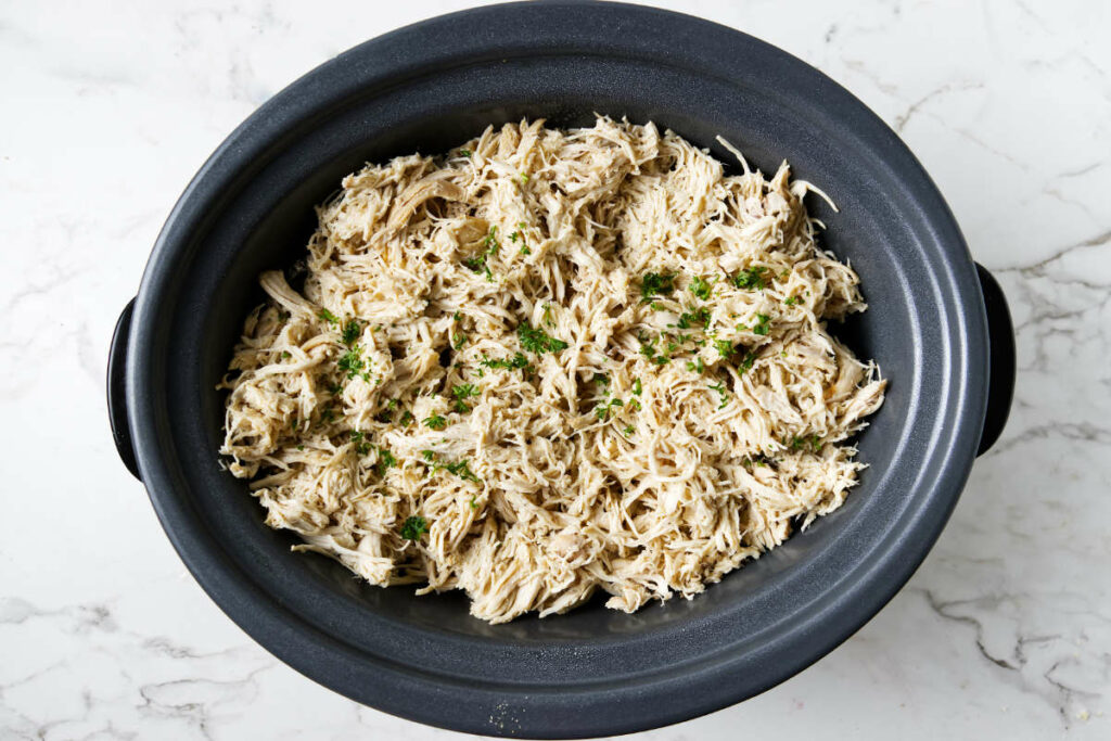 A crockpot filled with shredded chicken.
