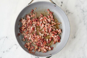 Cooking bacon bits in a skillet.