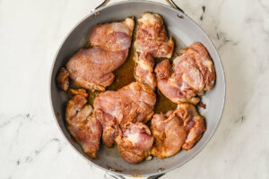 Browning the chicken in a skillet.