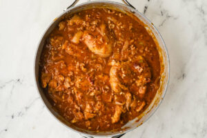 Simmering the chicken in the gravy.