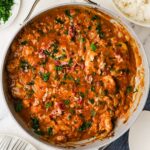Bacon onion smothered chicken in a skillet.
