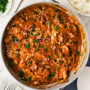 Bacon onion smothered chicken in a skillet.