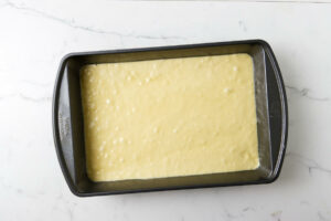 Pouring the cake batter into a baking pan.