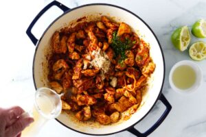 Adding chicken broth to panang curry.
