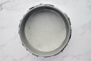 Lining a springform pan with parchment.