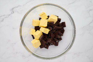 Combining butter and chocolate in a bowl.