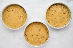 Dividing the cake batter into three pans.