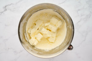 Adding the cream cheese to the mixing bowl.