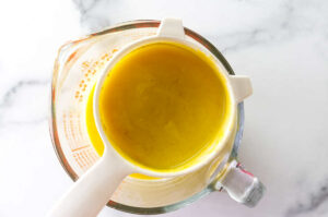 Straining pureed mango into a bowl.
