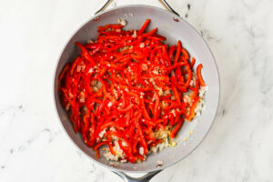 Bell peppers and onions in a skillet.