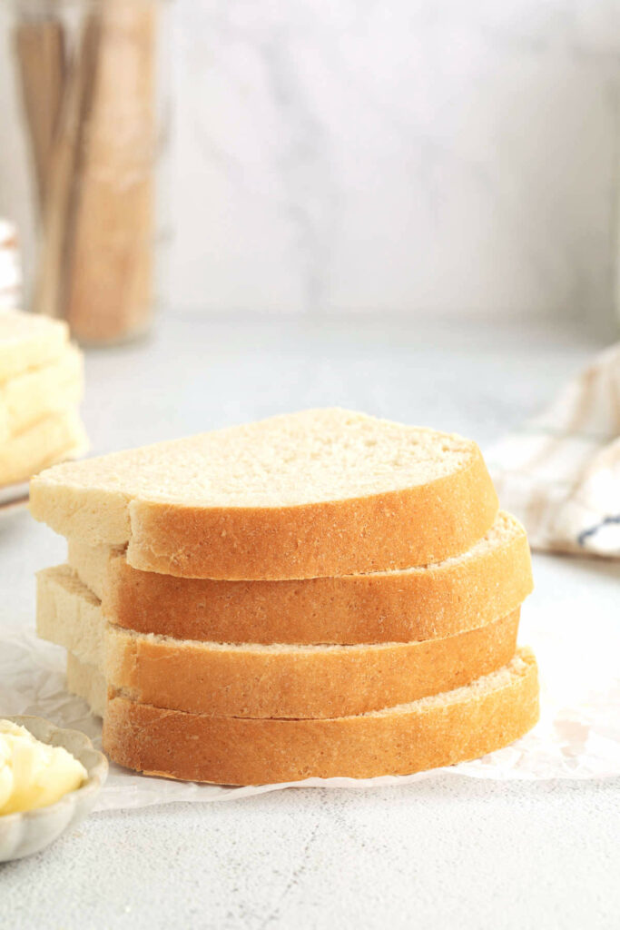 Several slices of homemade white bread on a counter.