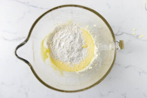 Adding flour to the cake batter.