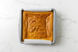 A freshly baked custard cake in a square pan.