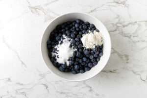 Blueberries tossed with sugar and thickener for blueberry cobbler filling.