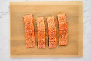 Seasoning salmon fillets with salt and pepper.