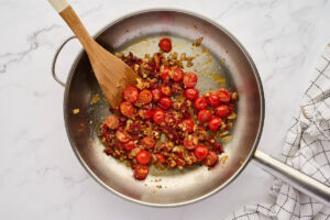 Adding sun dried tomatoes and tomato paste to the skillet.