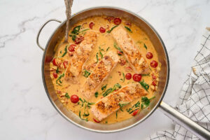Returning salmon to the cream sauce in the skillet.