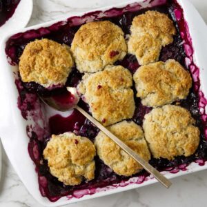 Easy blueberry cobbler in a square baking dish with bubbling blueberry filling.