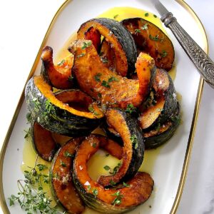 A platter with hot kabocha squash garnished with thyme.