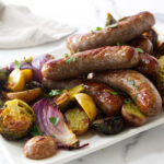 A platter of sausage and vegetables on a serving platter.