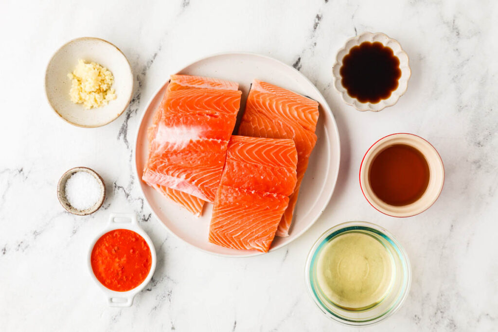 Ingredients used to make hot honey salmon placed on a white counter.