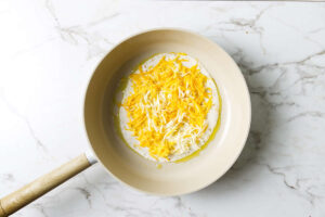 Melting cheese on a tortilla in a skillet.
