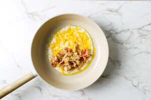Topping half the cheese with chicken mixture.