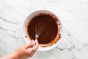 Whisking oil eggs and milk into cake batter.