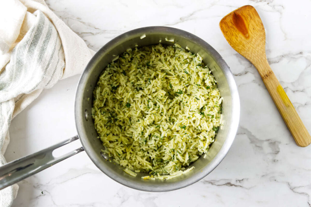 Greek rice pilaf finished with fresh herbs in a saucepan.