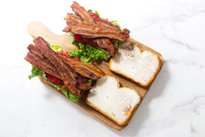 Classic BLT sandwich with crisp bacon, lettuce, tomato, and mayonnaise on toasted bread.