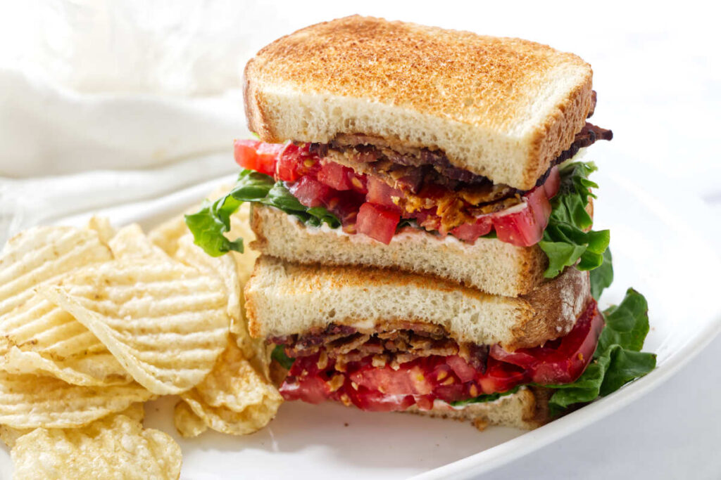 Homemade BLT sandwich with crunchy bacon and seasoned tomato slices.