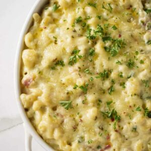 A white dish filled with smoked mac and cheese loaded with jalapeno peppers.