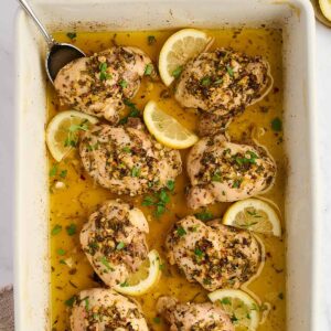 Lemon Greek chicken arranged on a serving platter with fresh parsley.